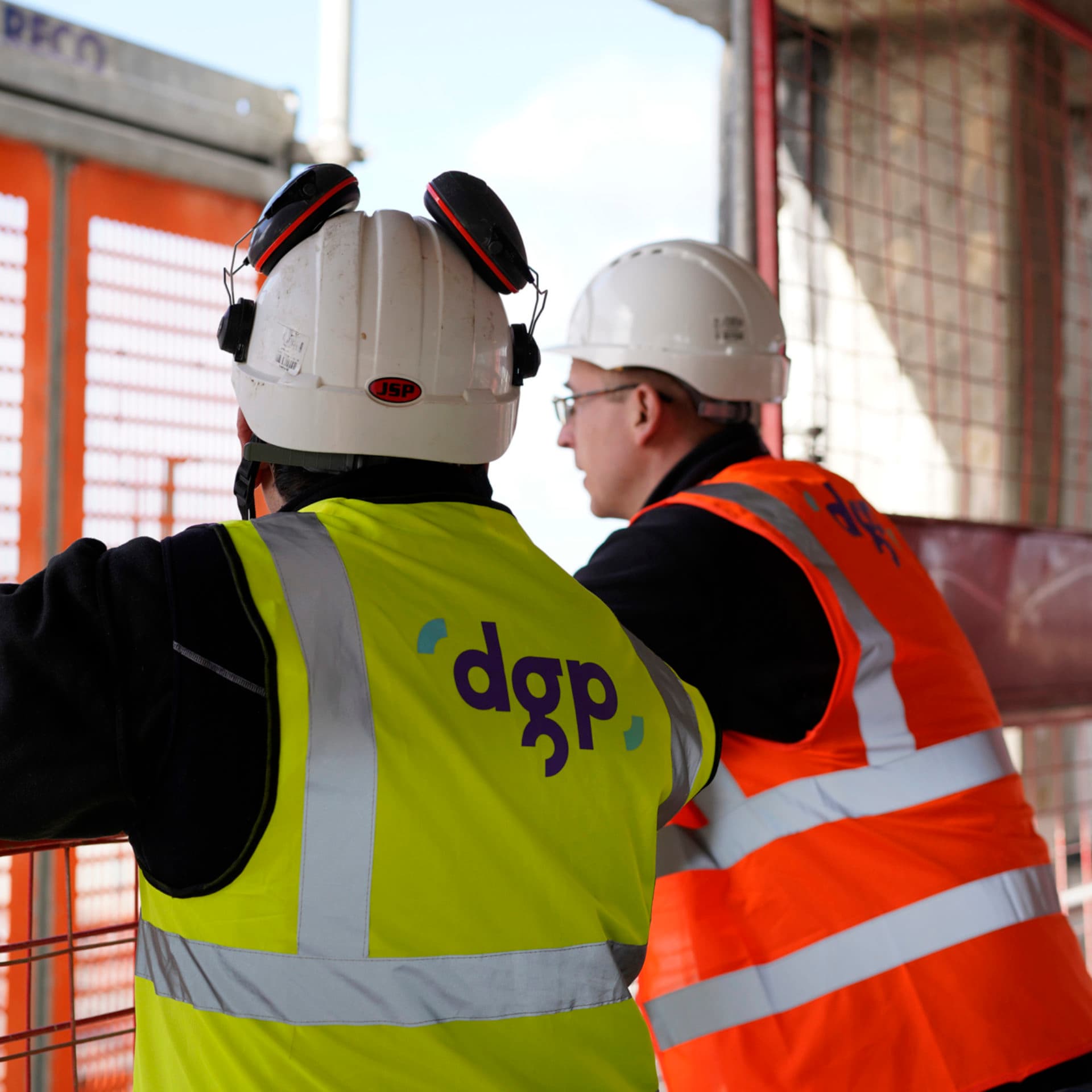 Two construction workers in PPE talking on site